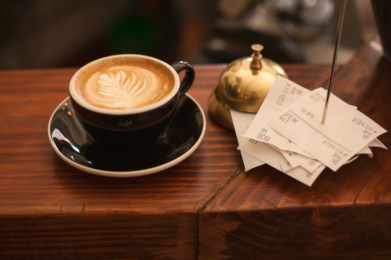 Coffee Cup and Receipts on a Cafe Bar